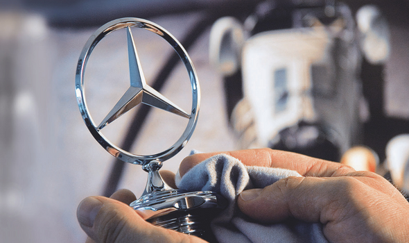 Person som holder opp en Mercedes-Benz stjerne.