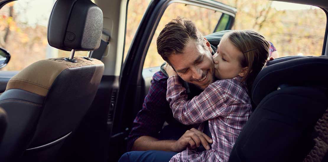 Far fester datter i barnesete i bil