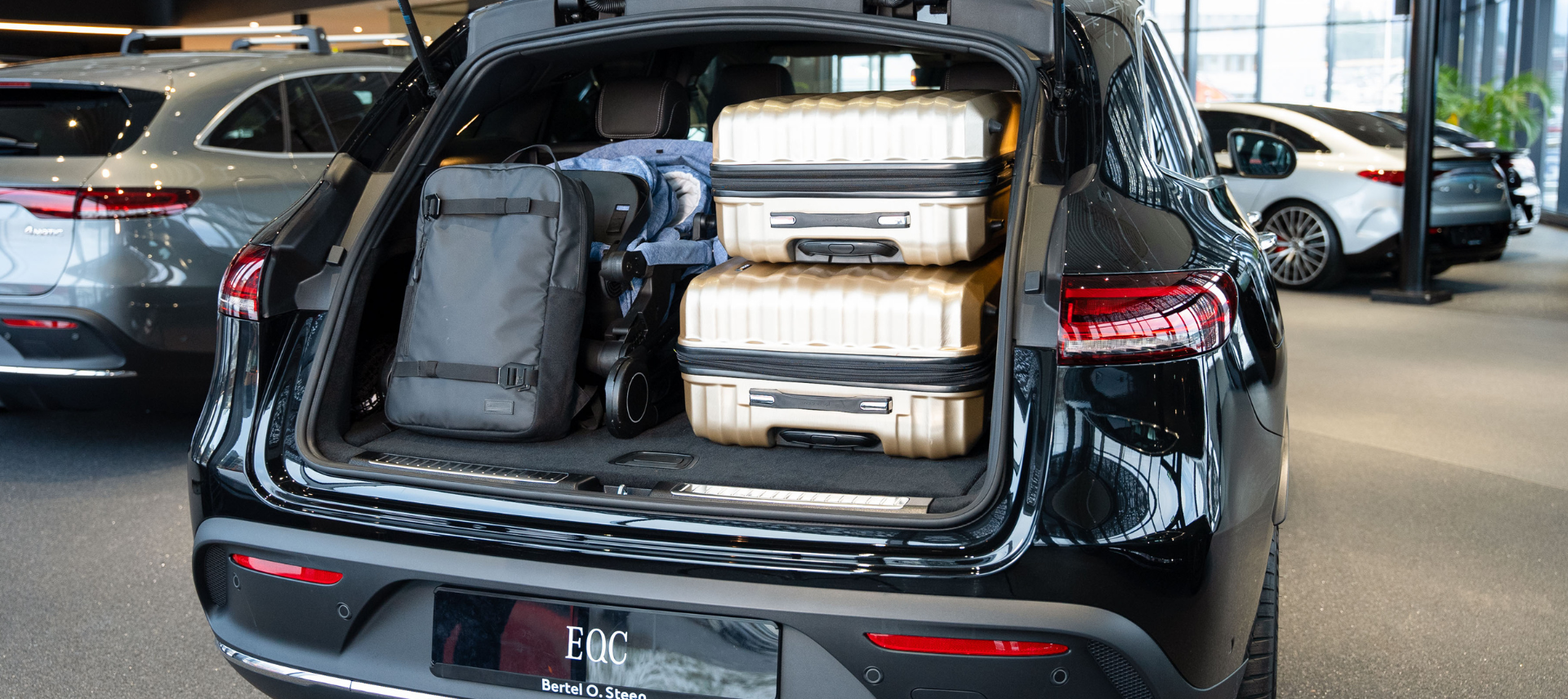Åpent bagasjerom på EQC 400 med barnevogn og kofferter.