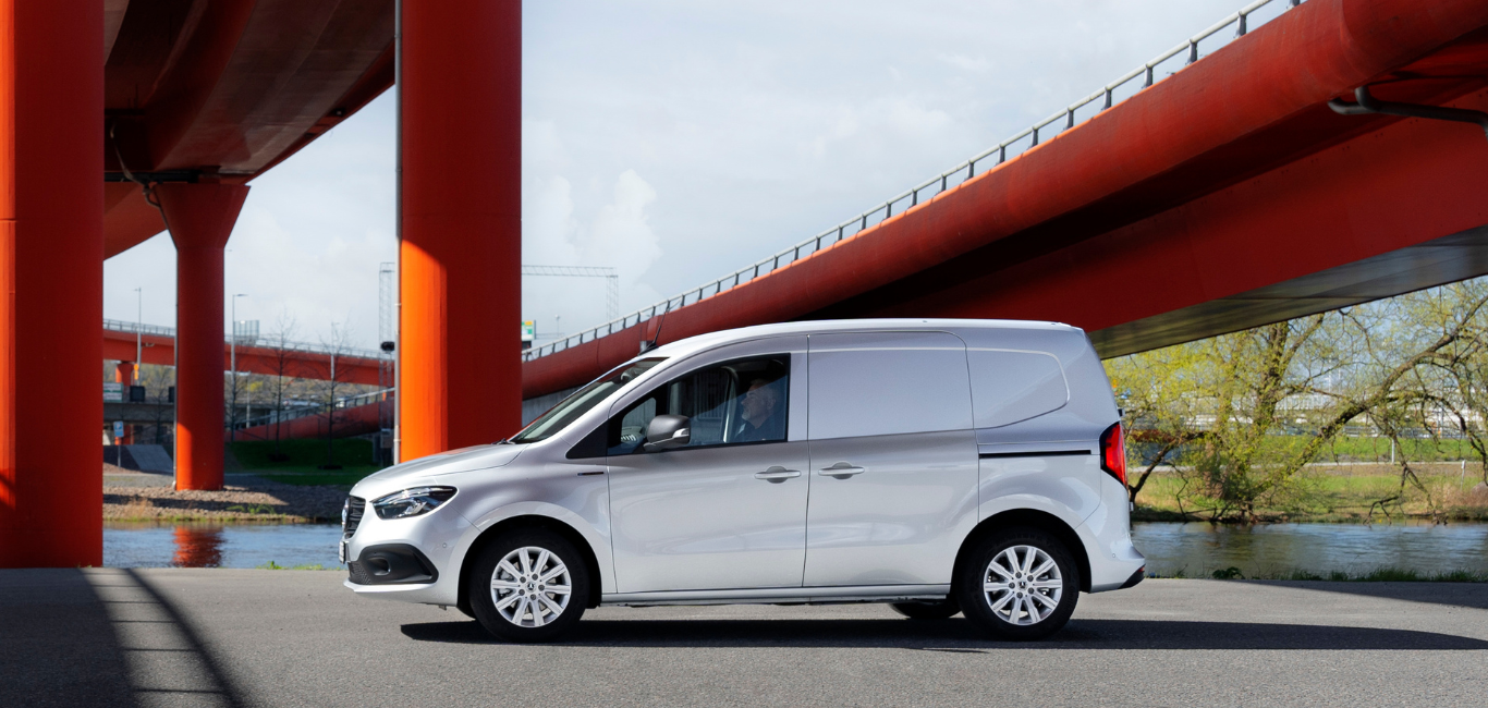 Nye eCitan fra Mercedes-Benz i sølvgrå metallic ved en bro.