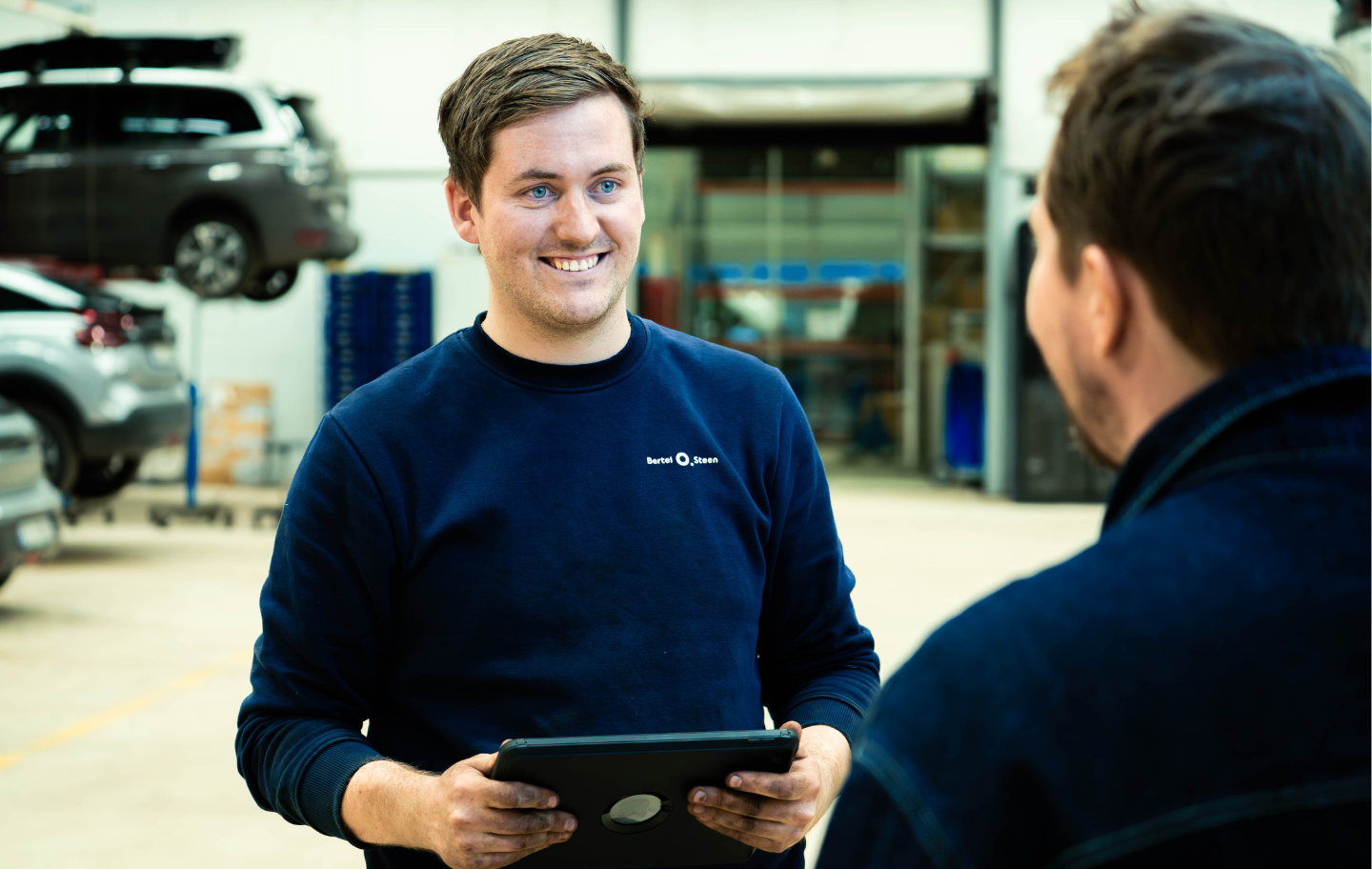 Mekaniker som tar i mot kunde til service på bilverksted