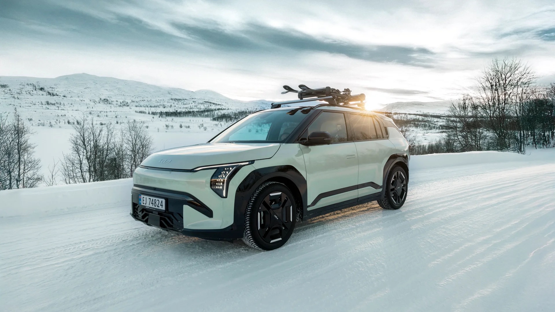 Kia EV3 i grønn lakk med skistativ på vintervei