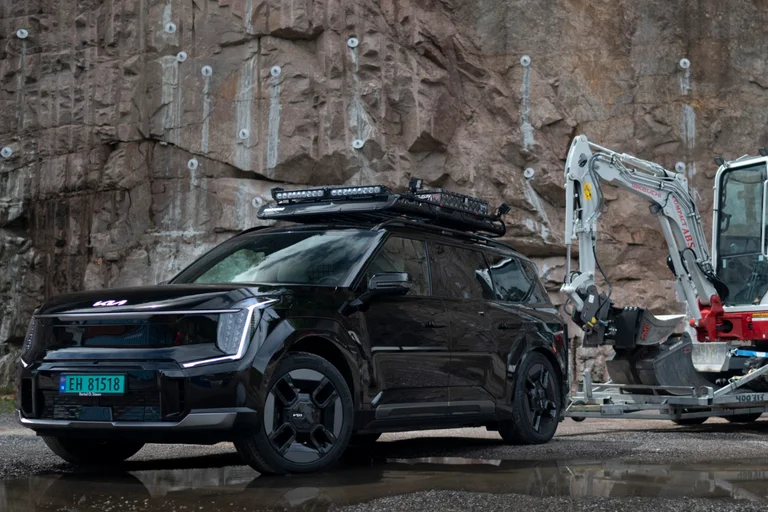 Ev9 varebil trekker en minigravemaskin på tilhenger