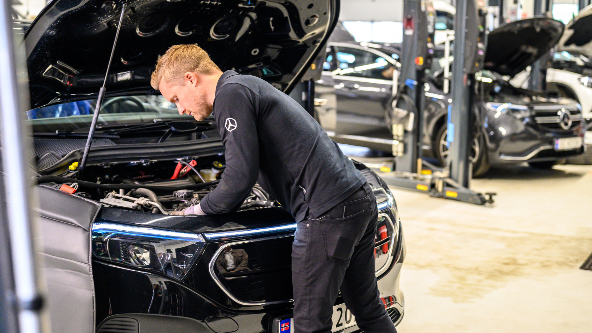 Servicetekniker undersøker høyvoltsbatteri og motorrom på en elbil