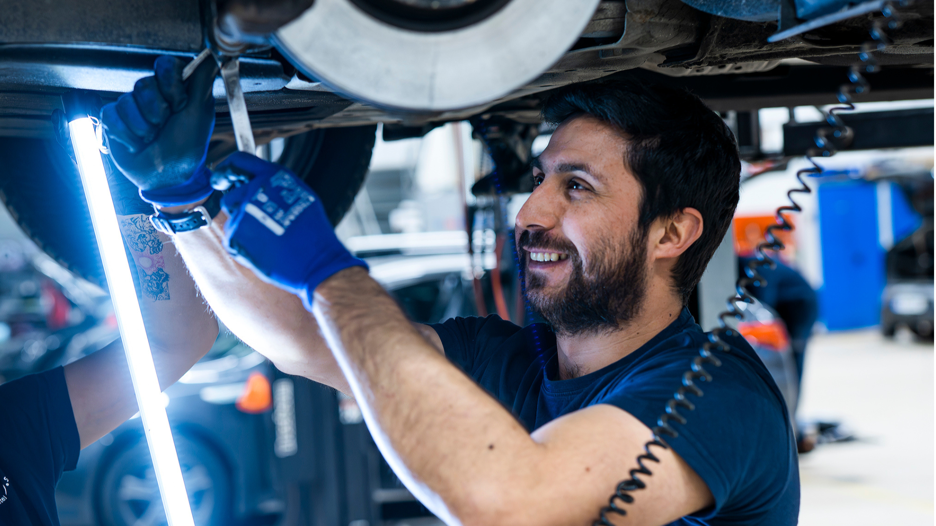 Mekaniker som skrur på en bil med serviceavtale på verkstedet