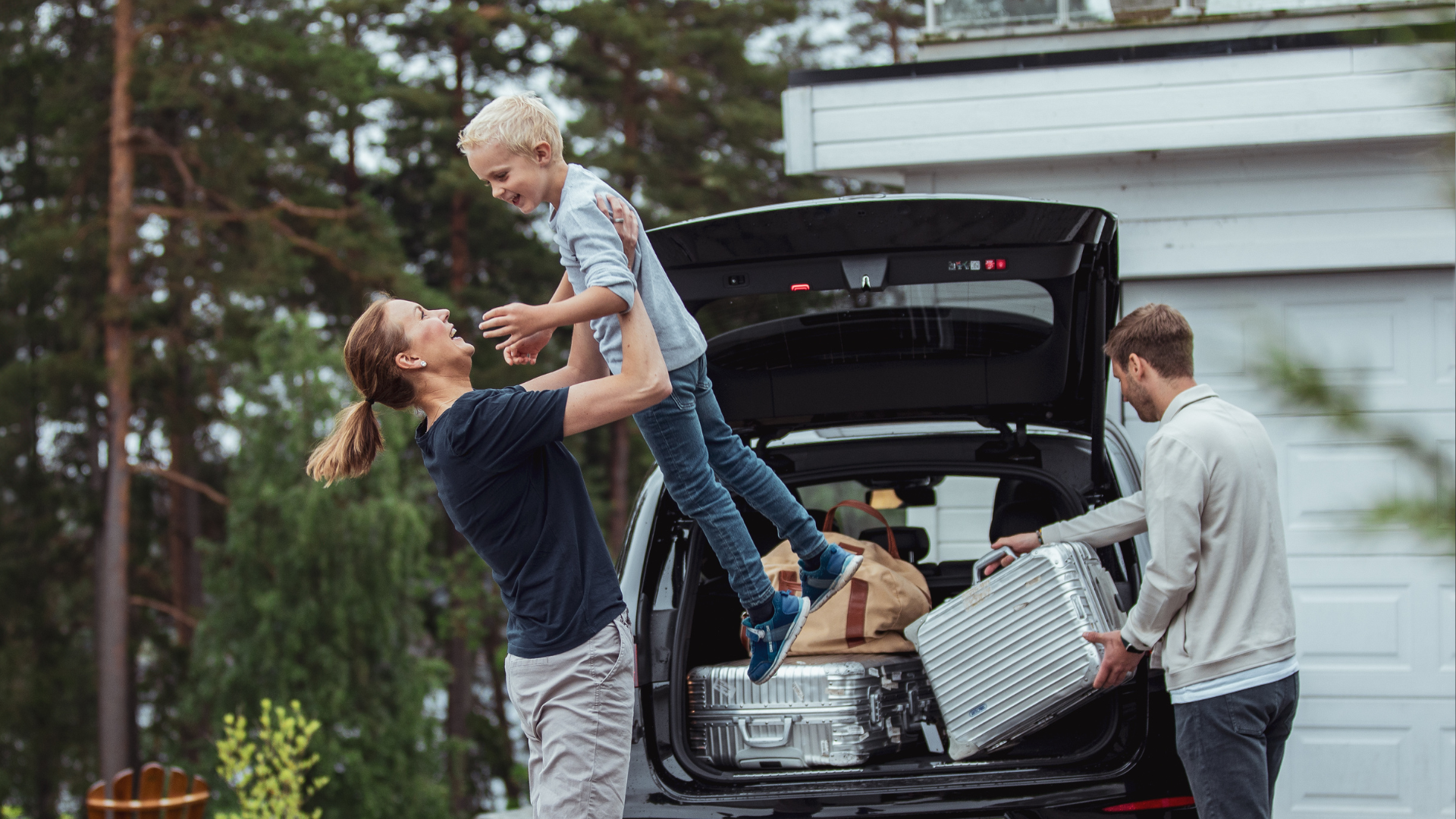 Familie med barn som leker utenfor bilen