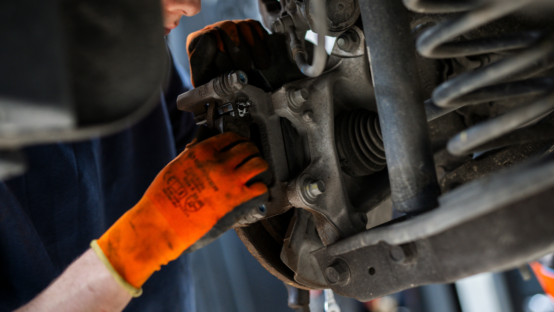 Mekaniker som skal bytte hjullager på en bil på verksted