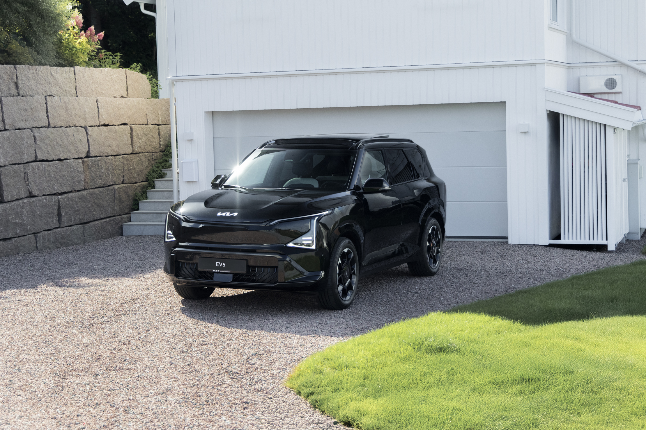 Kia EV5 i Norge foran garasje