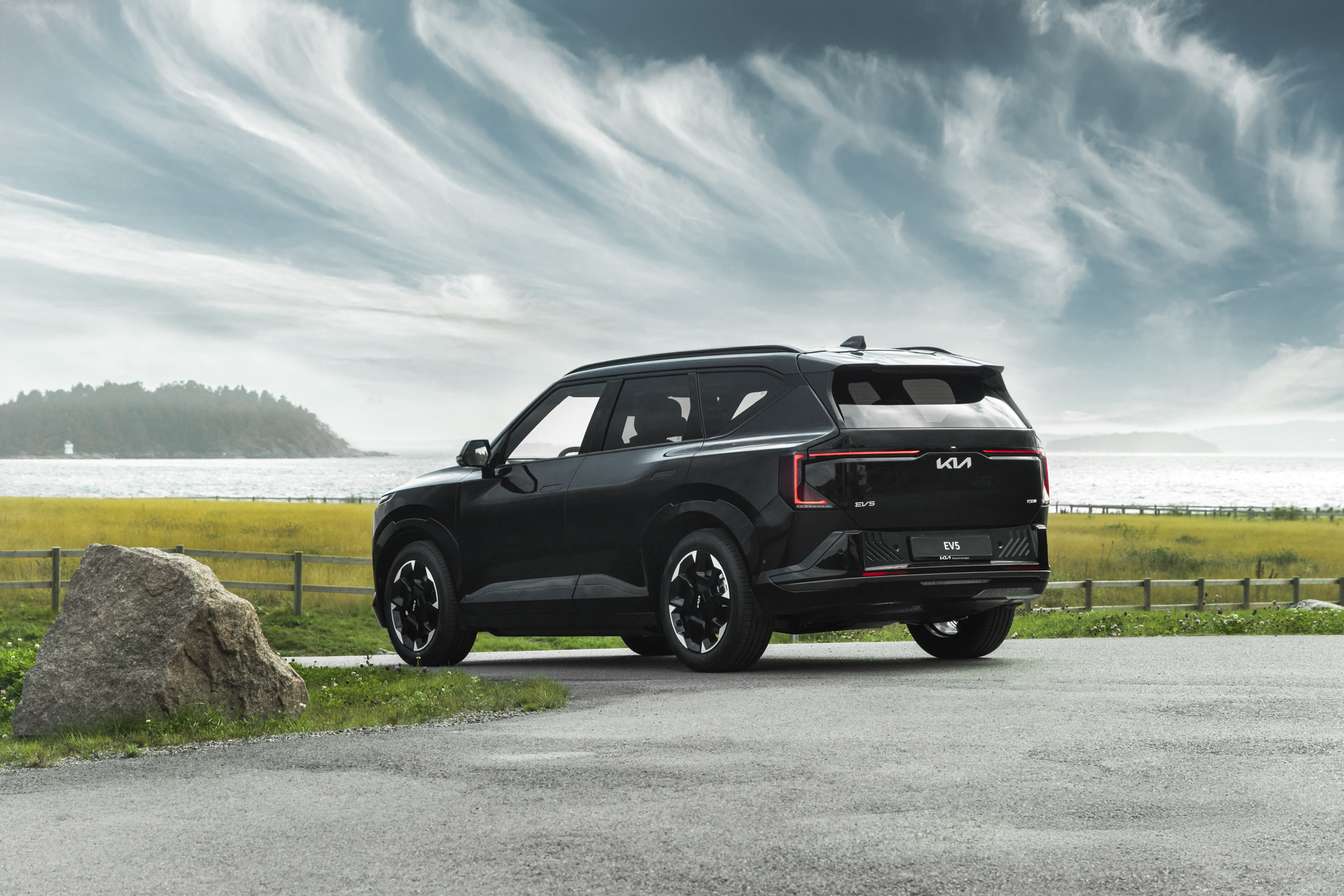 Kia EV5 sett bakfra parkert ved en strand