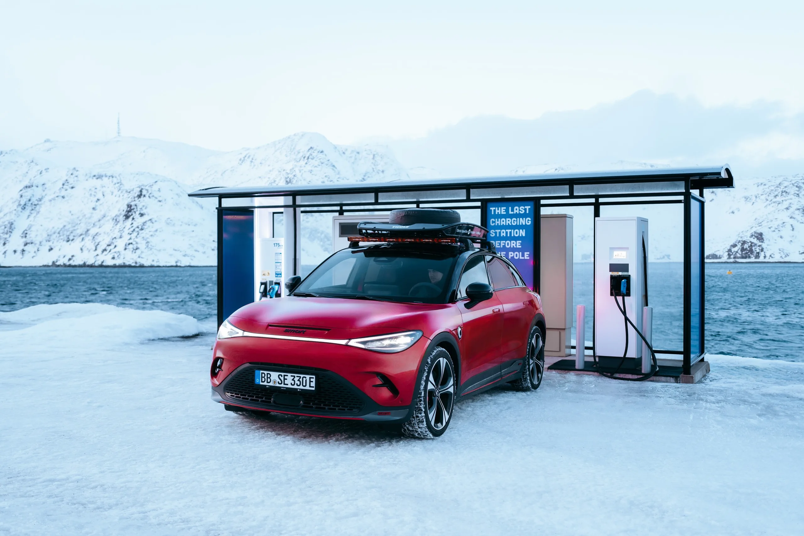 Rød smart #3 lades ved en ladestasjon under vintertest i Norge
