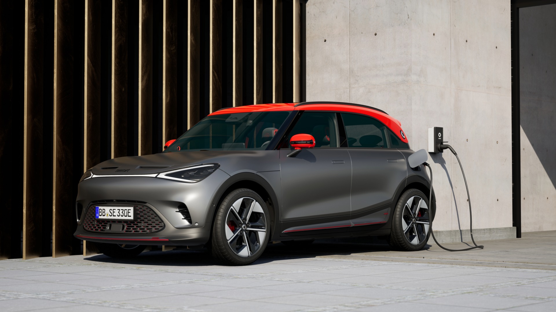 smart #1 BRABUS lades ved en vegglader utenfor en moderne bygning