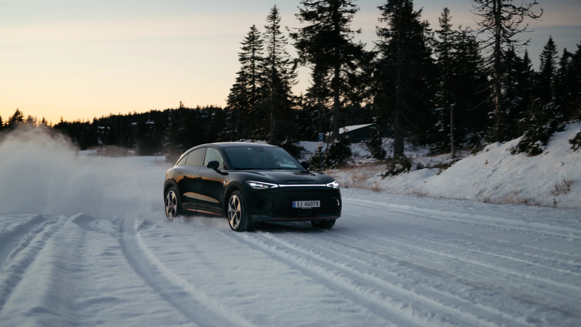 smart #3 på snødekt vei med snøsprut i vinterlandskap