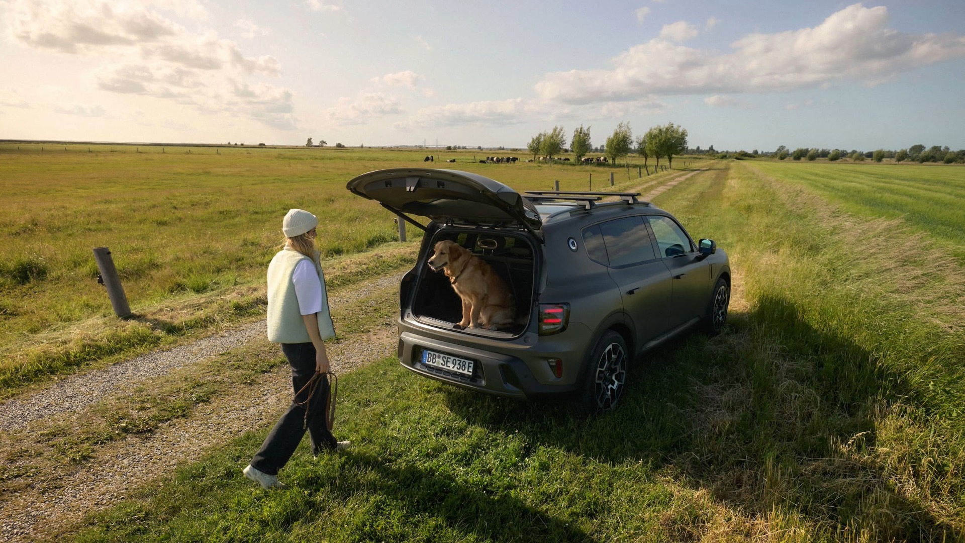 smart #5 parkert ved en grønn eng med åpent bagasjerom, en hund og person ved bilen