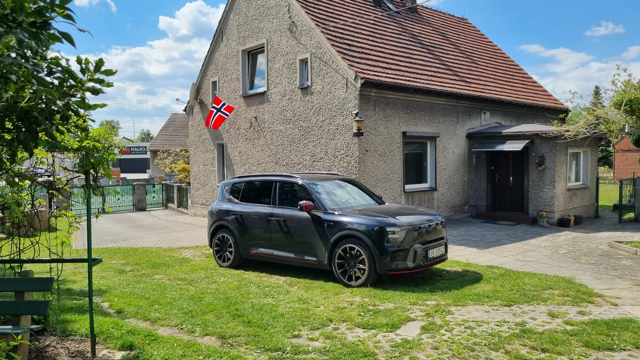Sort smart #5 BRABUS parkert foran et hus med norsk flagg