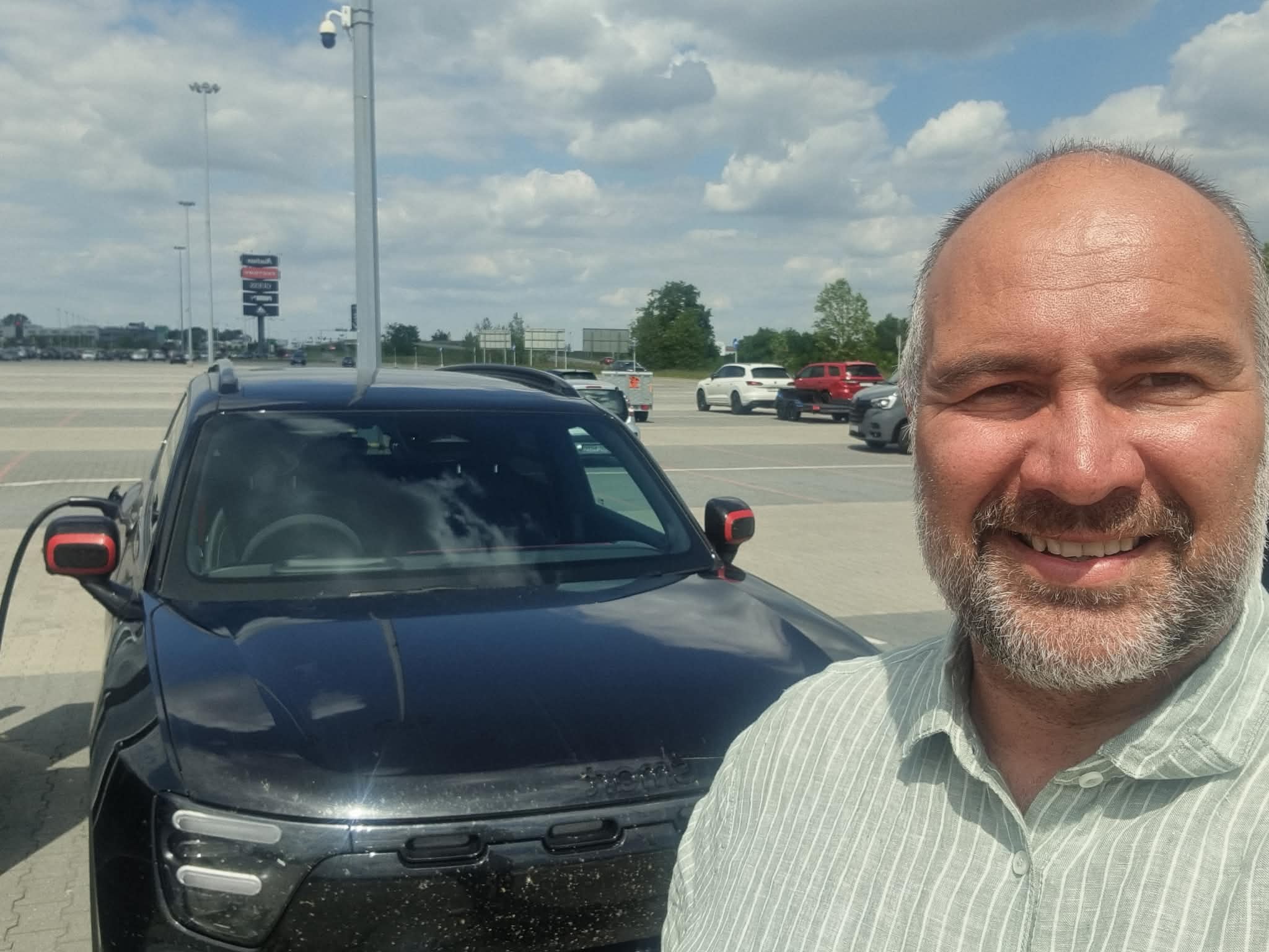 Tommy Bjørkebo foran sin sorte smart #5 BRABUS på en ladestasjon