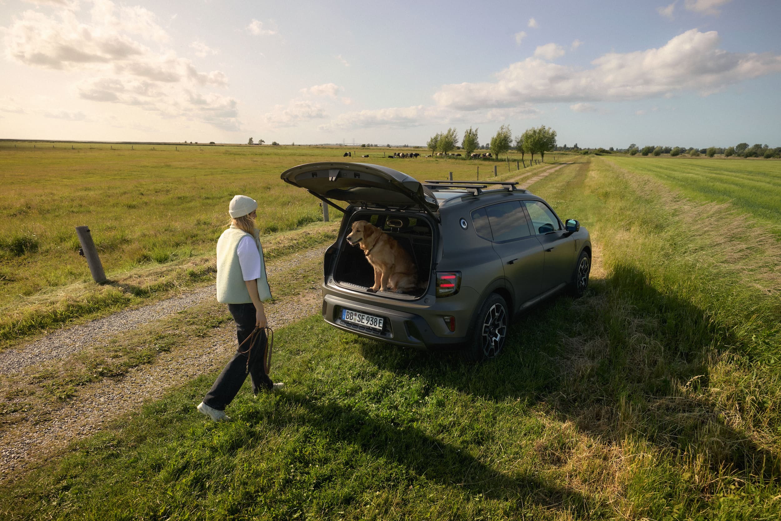 Hund i det åpne bagasjerommet på en smart #5 med en person ved siden av bilen