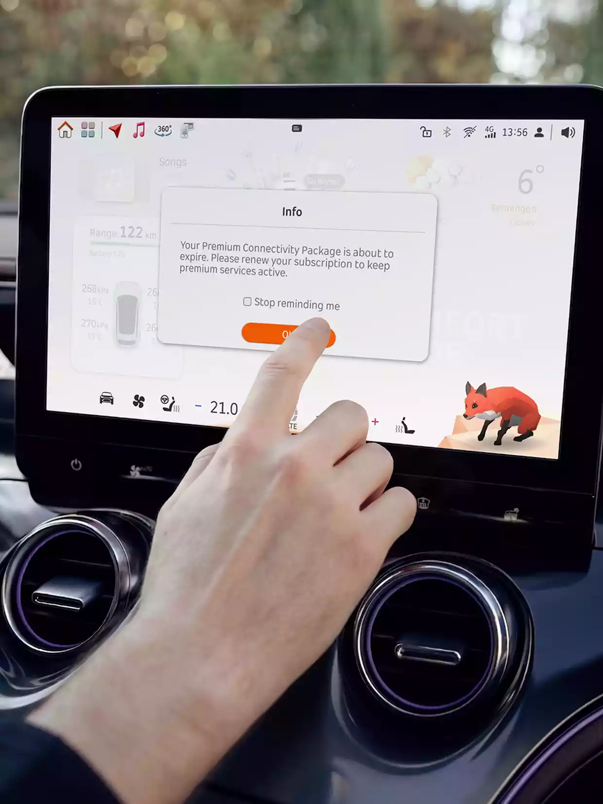En hånd trykker på en melding om Premium Connectivity Package på bilens midtskjerm