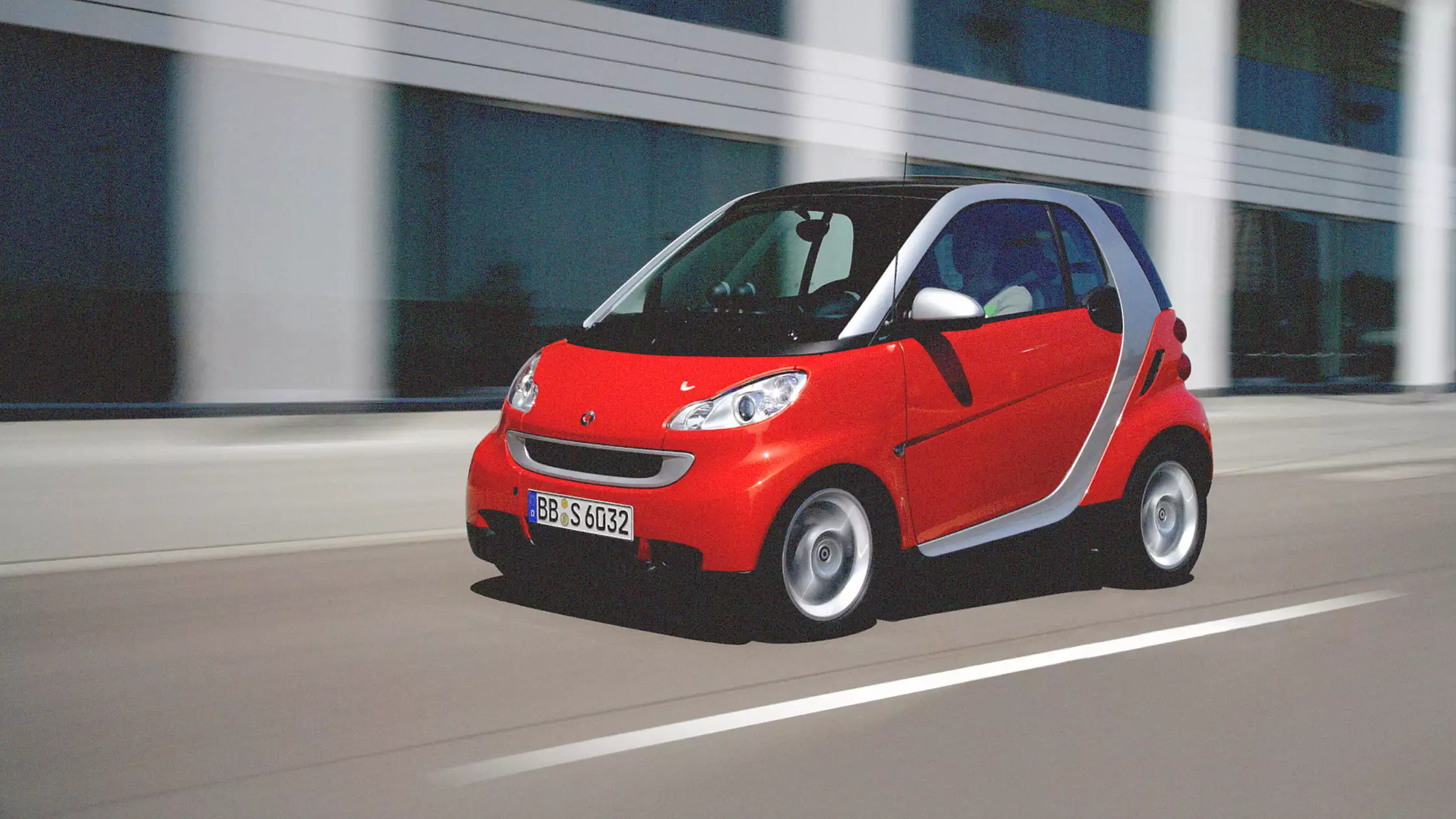 Rød smart fortwo på vei gjennom byen