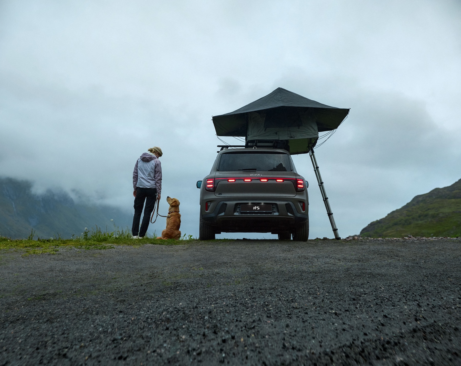 smart #5 med taktelt parkert i fjellandskap, med en person og hund ved siden av bilen