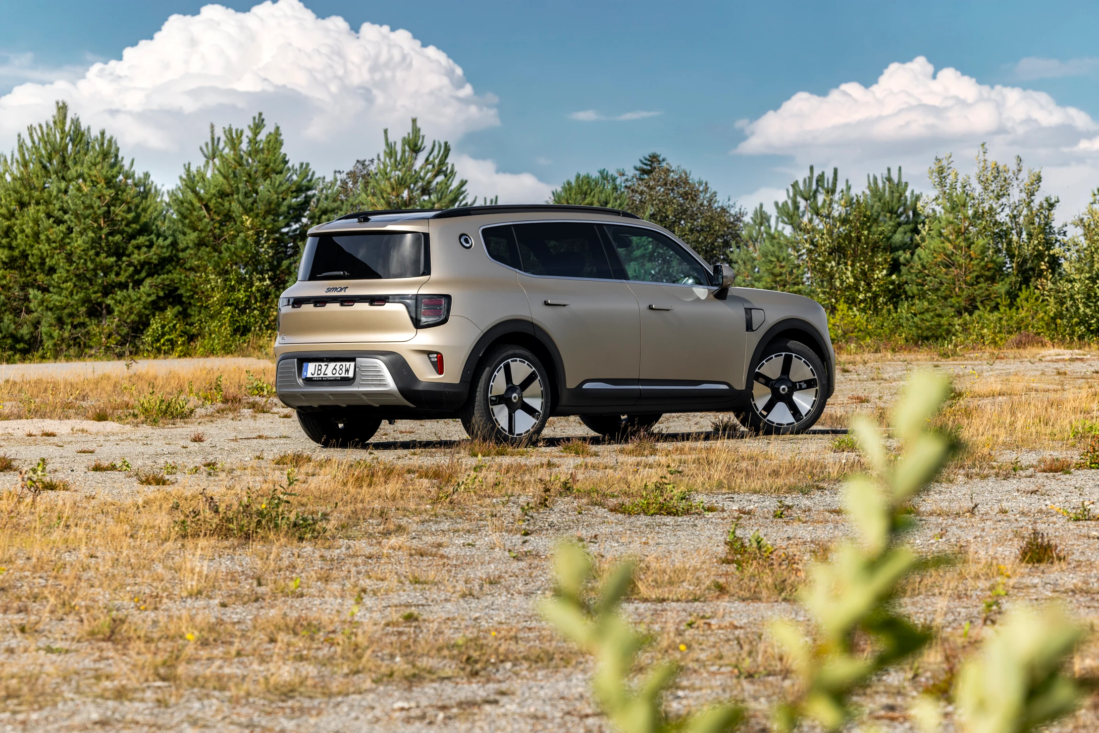 smart #5 Premium sett skrått bakfra, parkert på en grusvei omgitt av natur