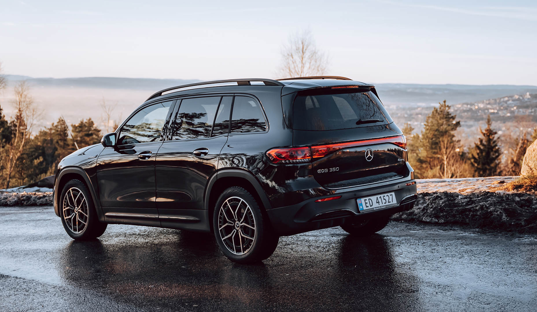 Mercedes-Benz EQB står parkert på en vei ruvende over en by