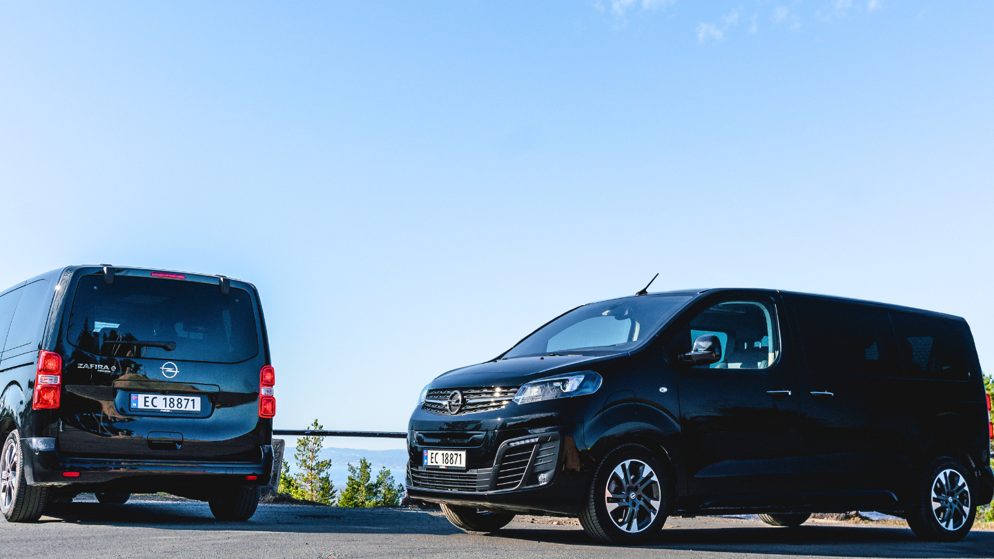 To Opel Zafira-e i svart metallic oppstilt i solen