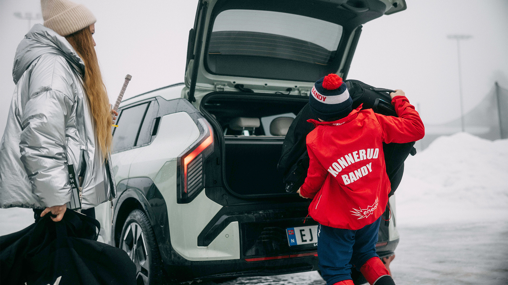 Småbarnsmor med ishockey-gutt med en Kia EV3