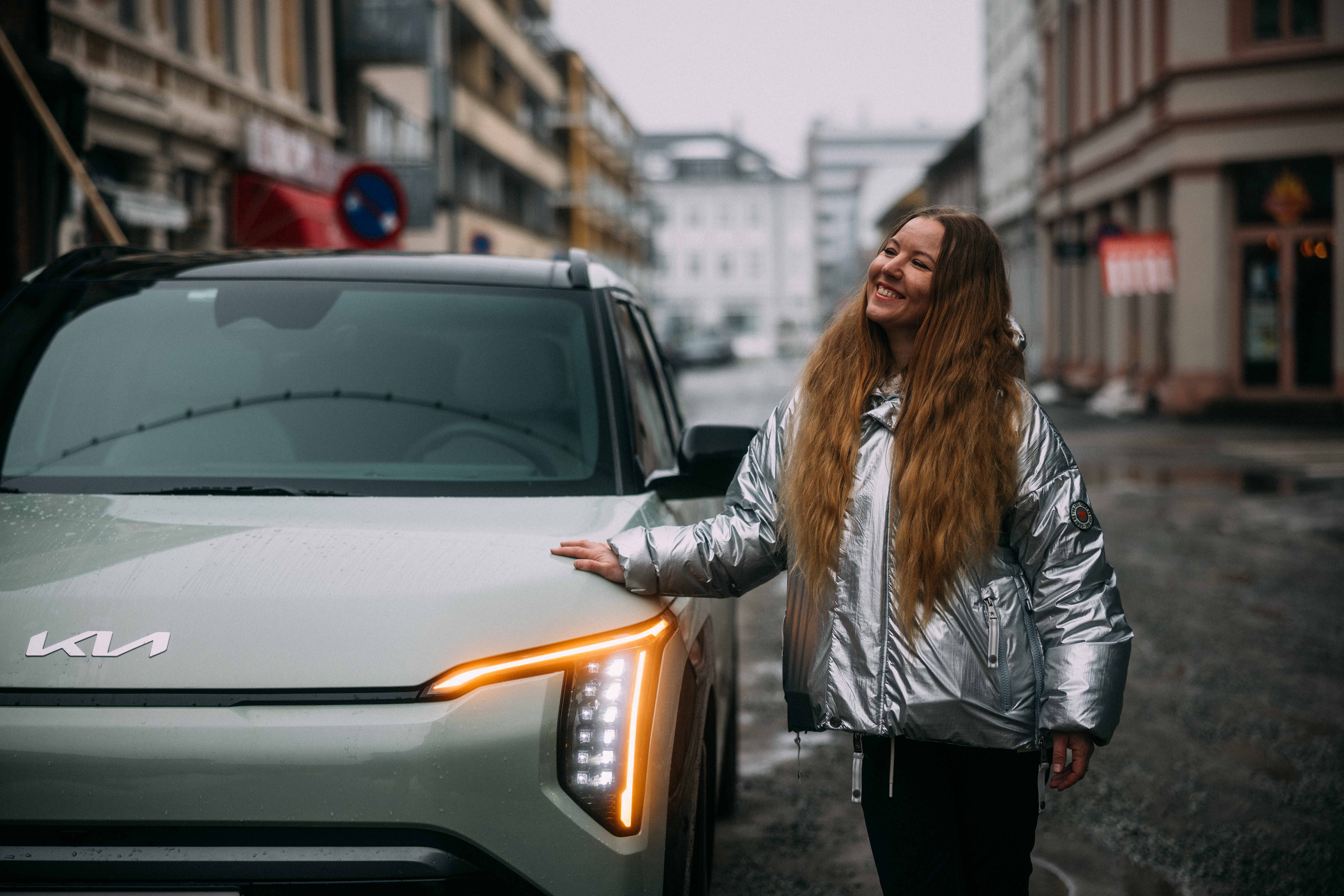 Småbarnsmor som poserer med en Kia EV3