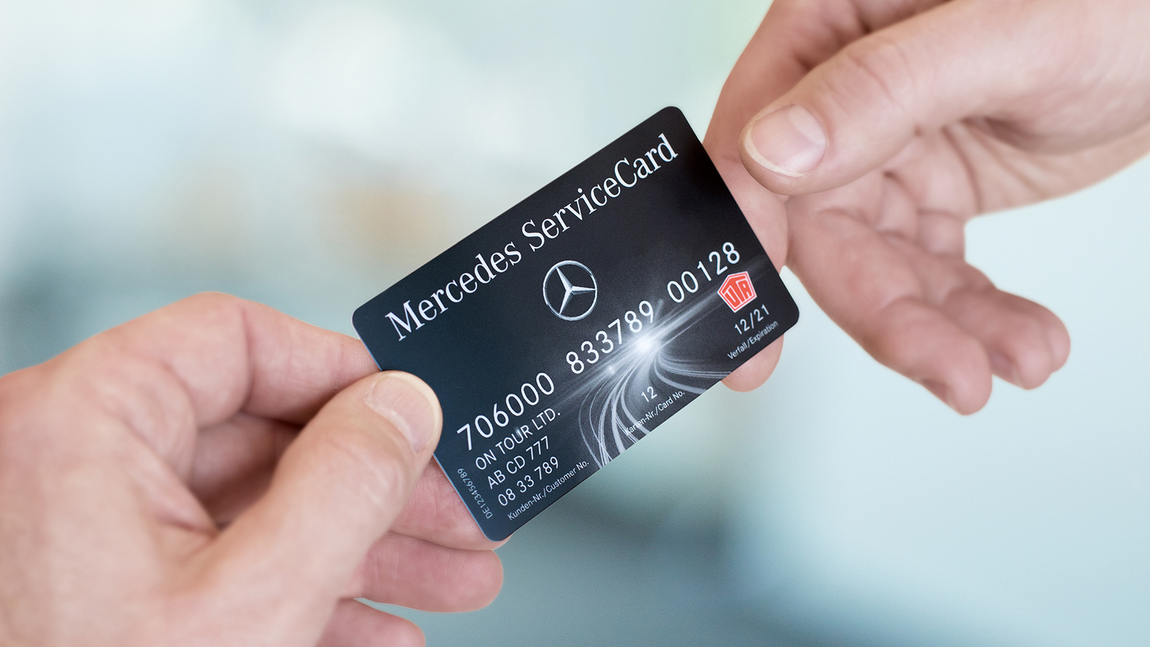 Bilde av to hender som holder et Mercedes ServiceCard