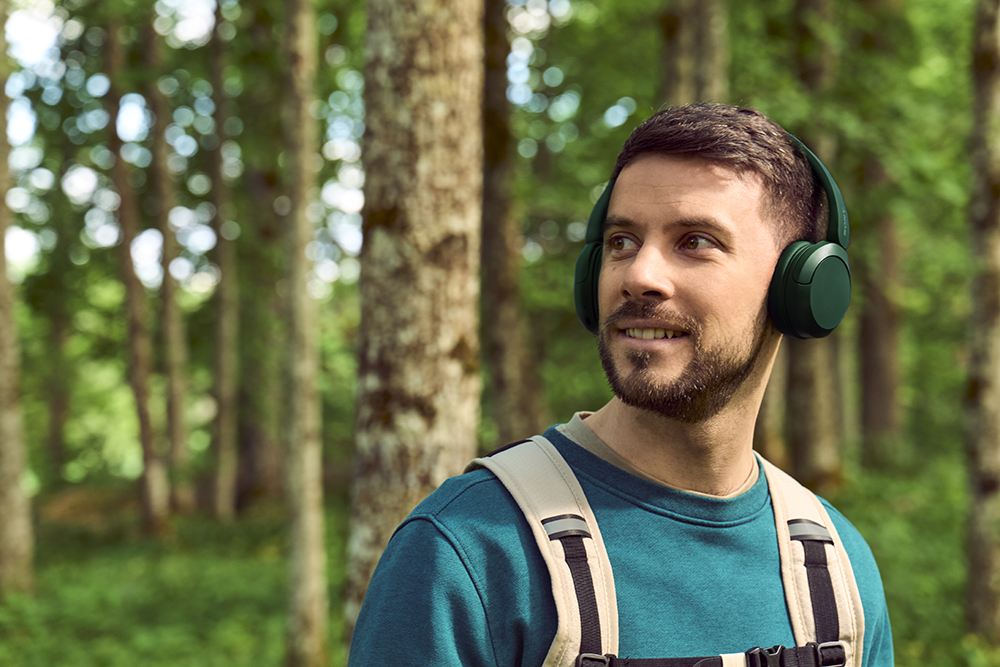 Lytting til lydbok med hodetelefoner på tur i skogen