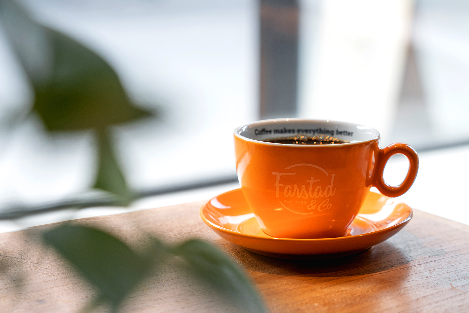 Coffee mug in window with Farstad logo on it
