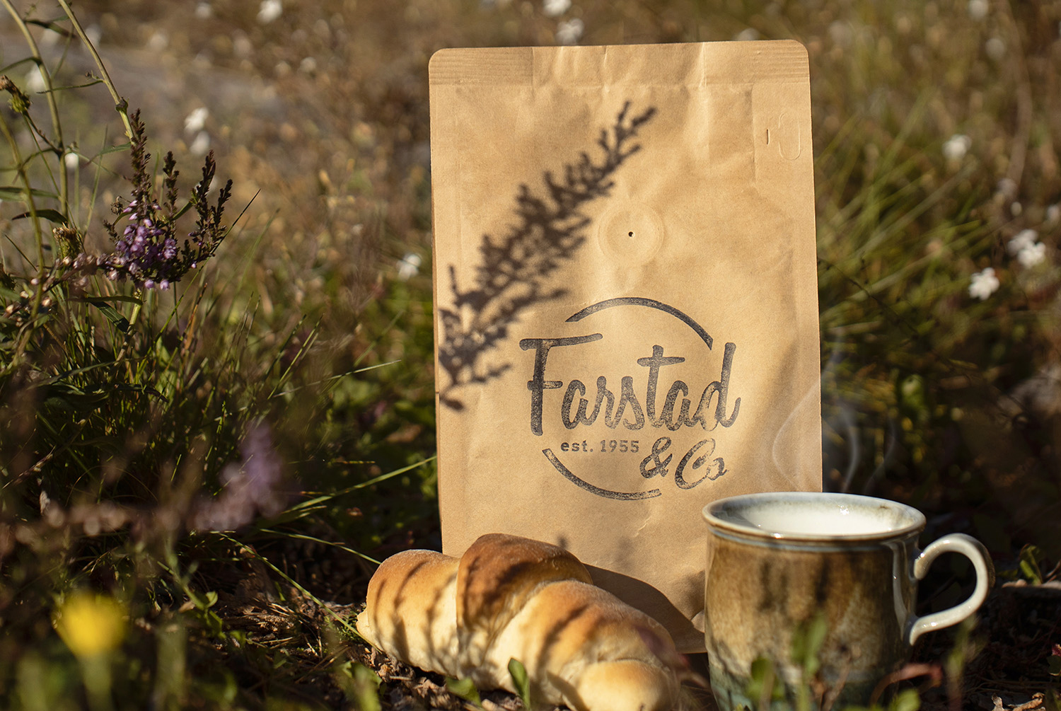 Coffee bag, croissant and a mug outside in the heather