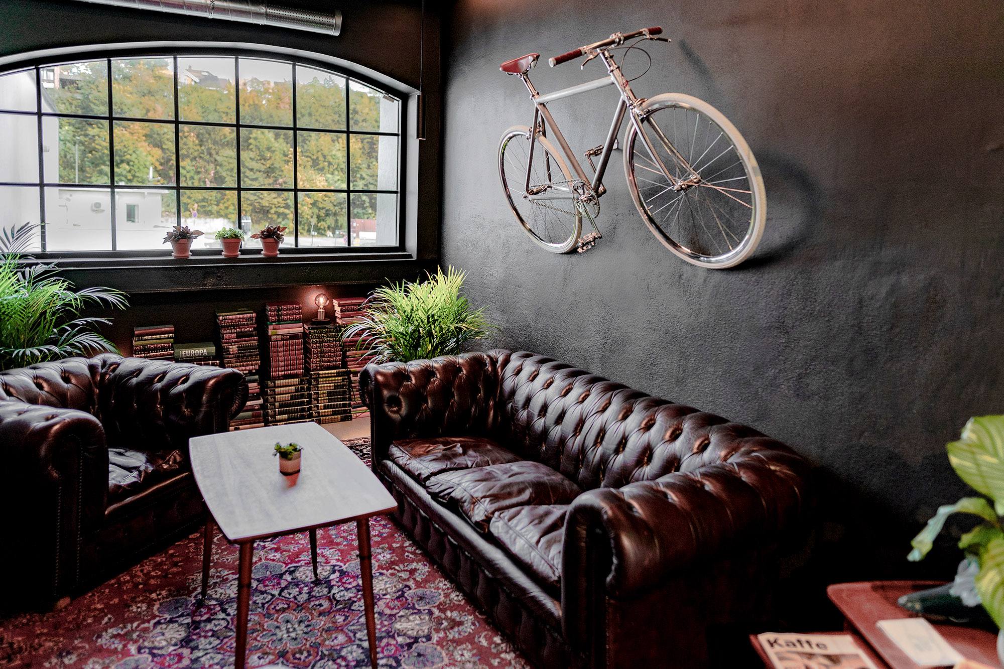 Meeting room with two leather sofas and a coffee table in Brooklyn style decor and a bike on the wall