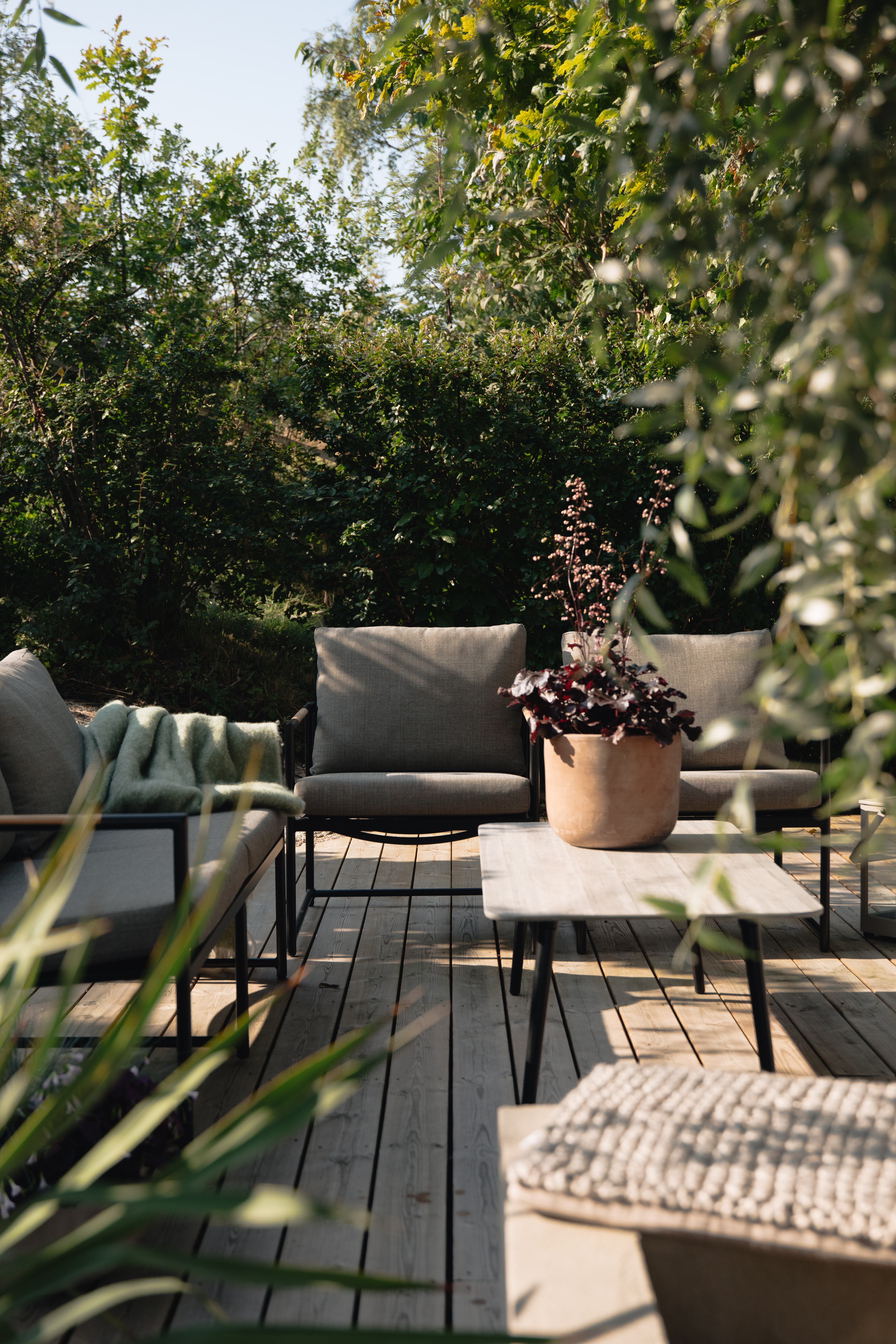 Sofagruppe med 2,5 seter sofa, 2 stoler, bord .sort, med grå puter i olefin og teak detaljer. Bord med grå keramisk topp.