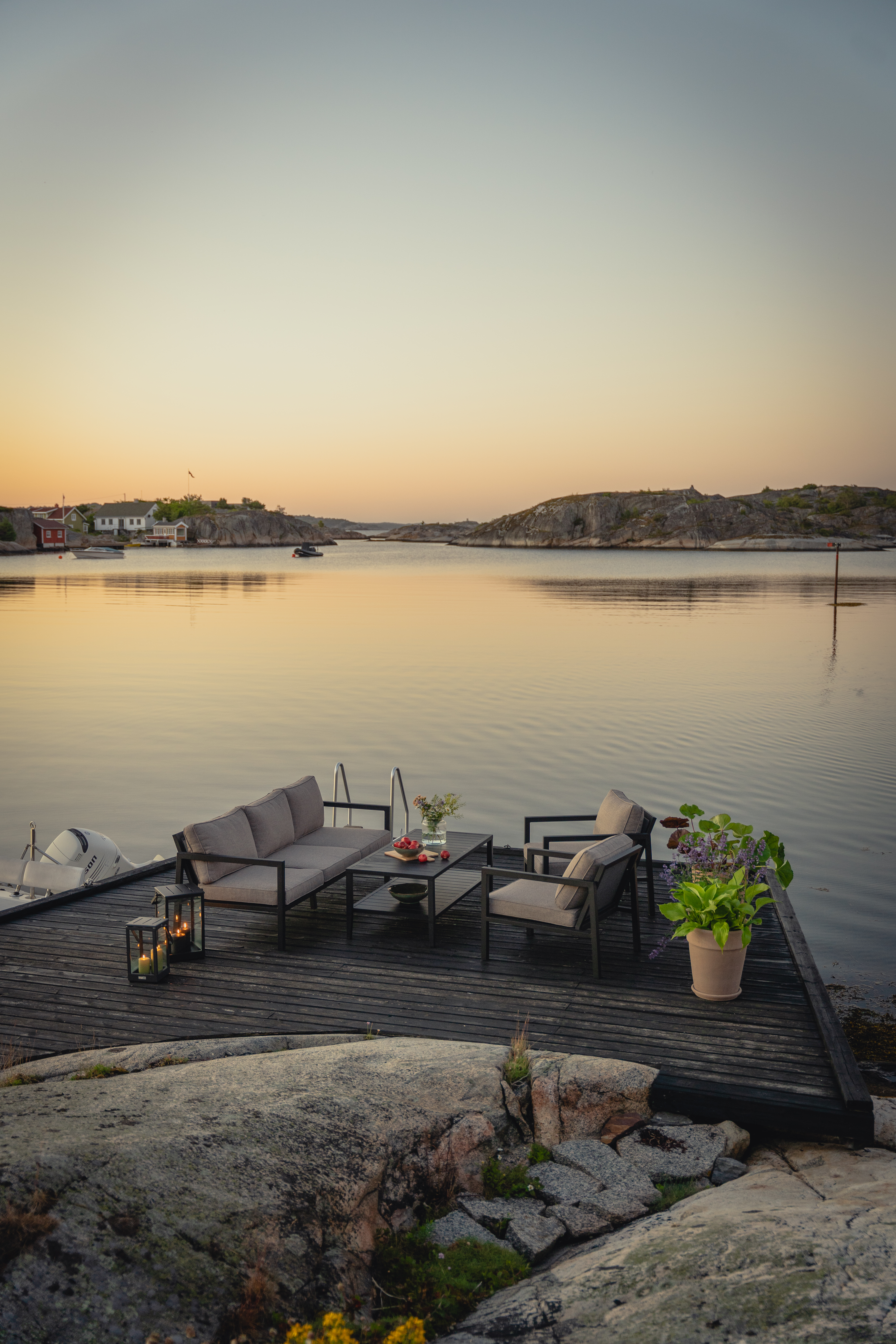 Sofagruppe med 3-seter sofa, 2 stoler og bord. I sort aluminium og beige puter om kvelden.