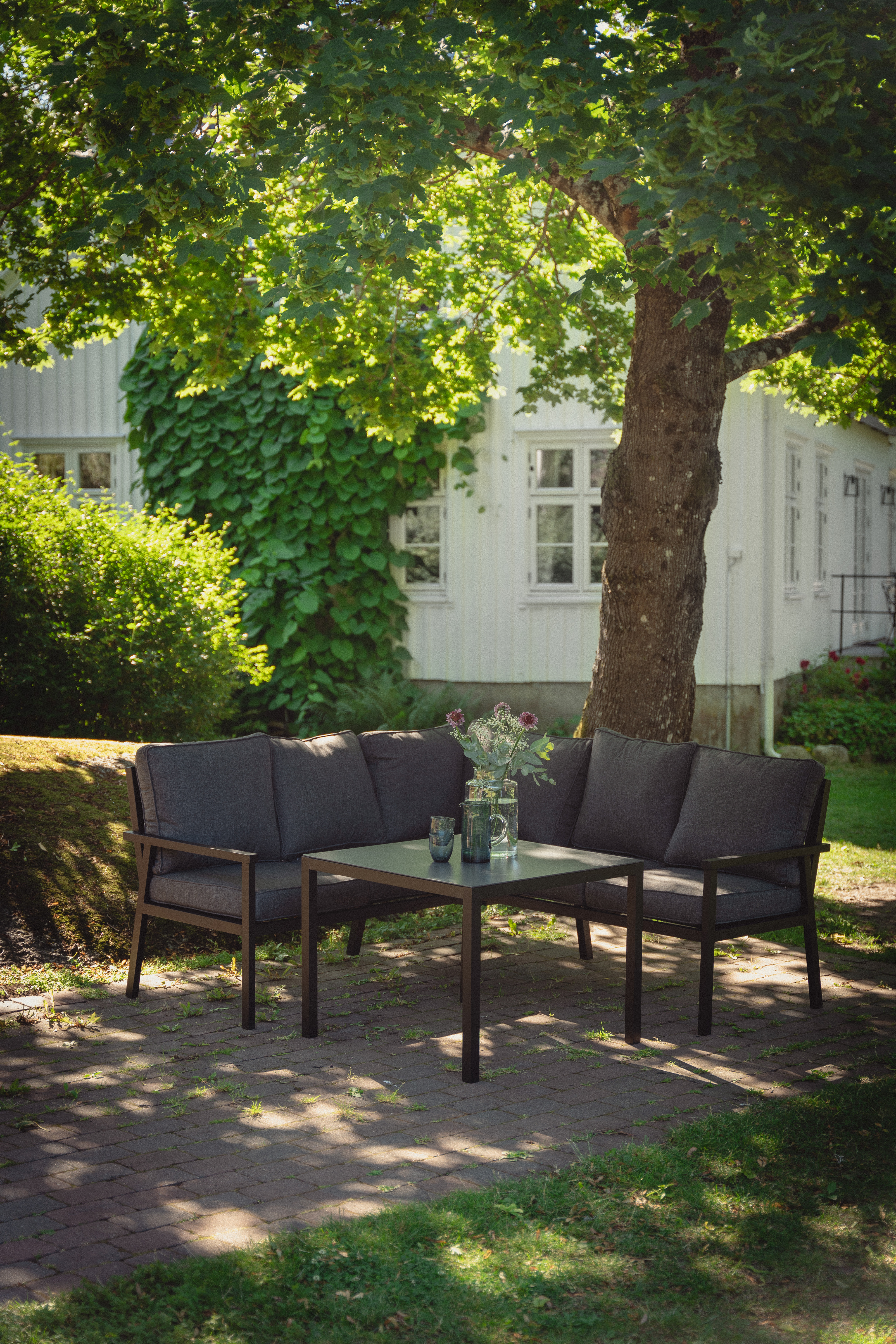 Rana sort hjørnegruppe med sofa og bord i sort aluminium.
