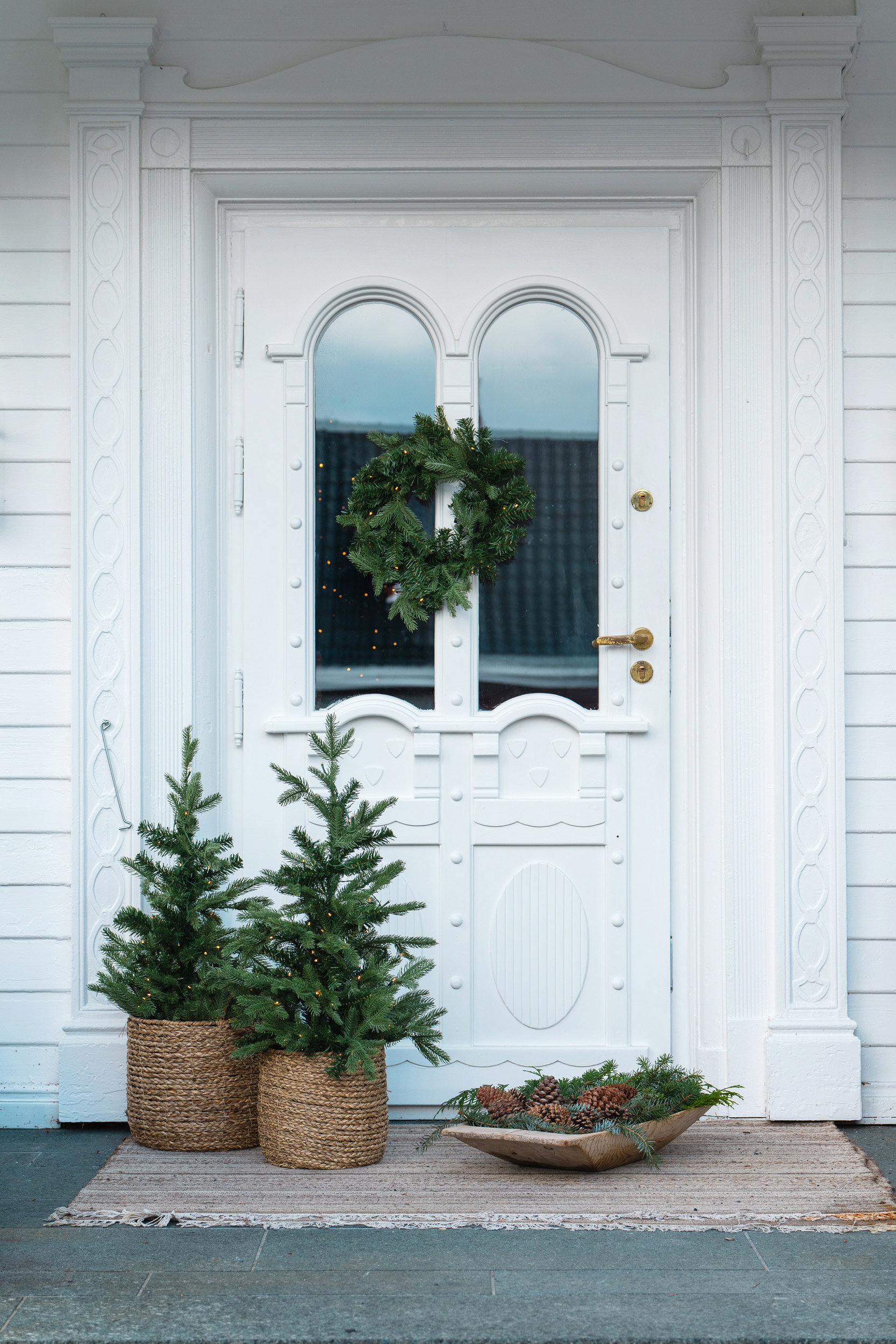 Pynte inngangsparti jul med dørkrans og minitrær på batteri