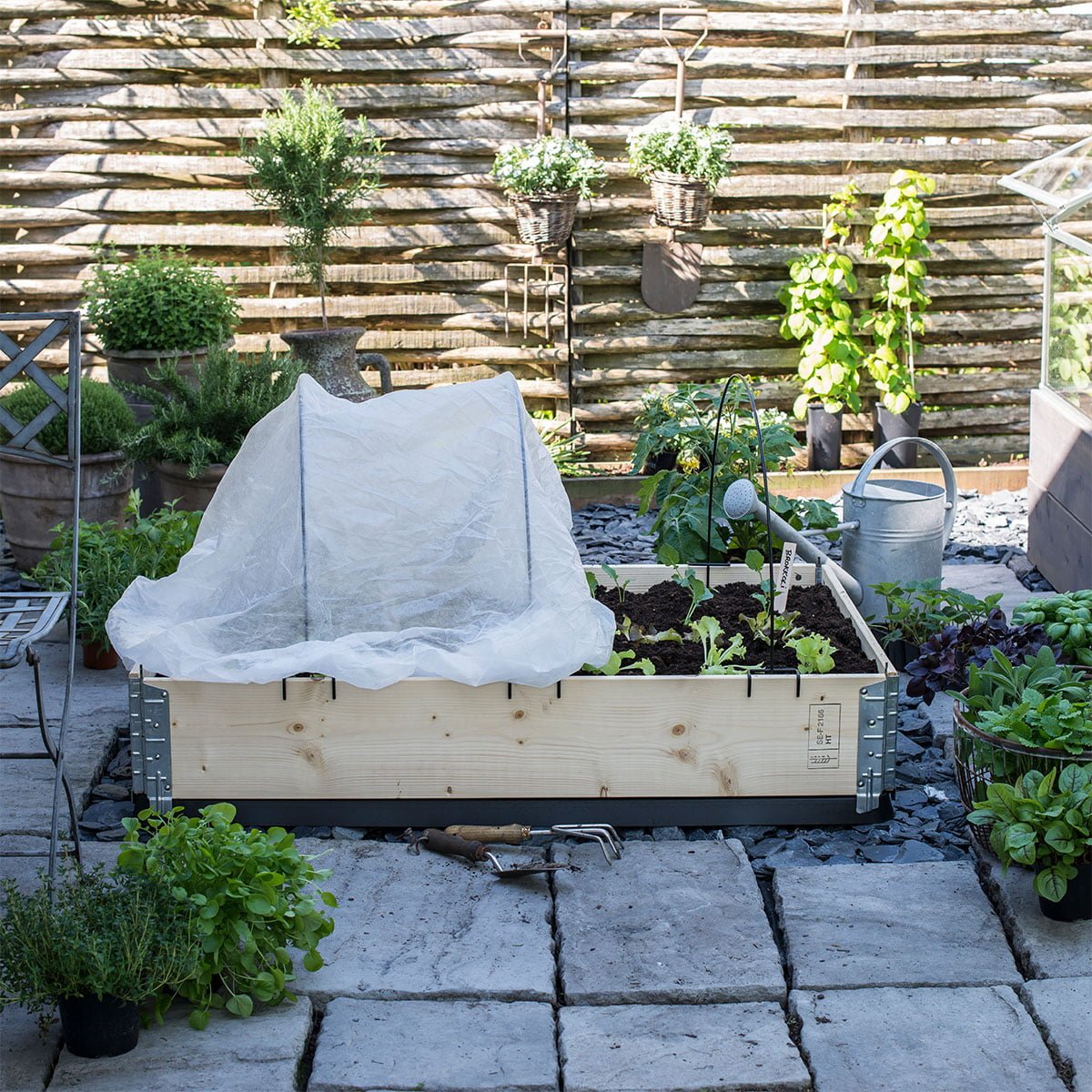 Pallekarm med grønnsaker halvveis dekket av fiberduk