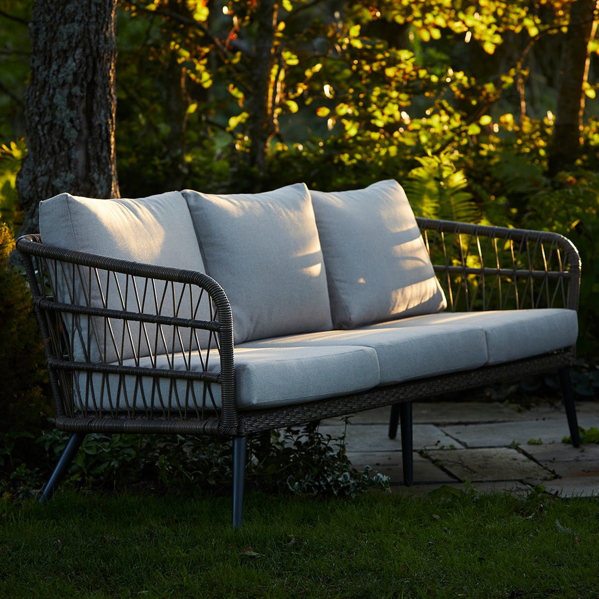 Nydelig 3 seters sofa i naturfarget kunstrotting. fletten på kunstrottingen og de lyse putene gir et romantisk, stramt utrykk