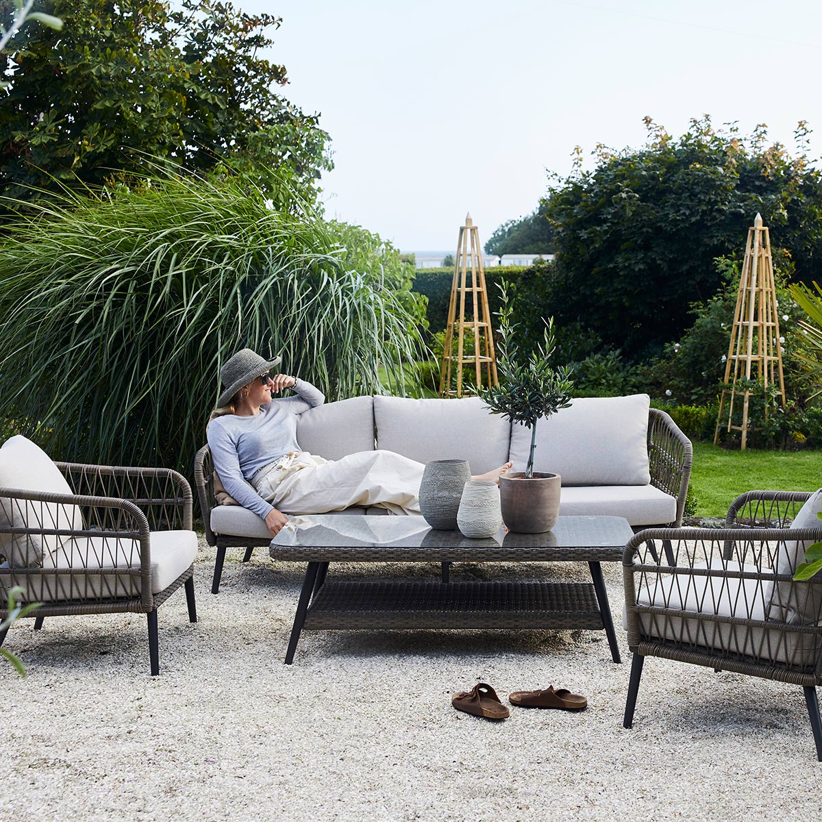 Nydelig sofagruppe i naturfarget kunstrotting. fletten på kunstrottingen og de lyse putene gir et romantisk, stramt utrykk