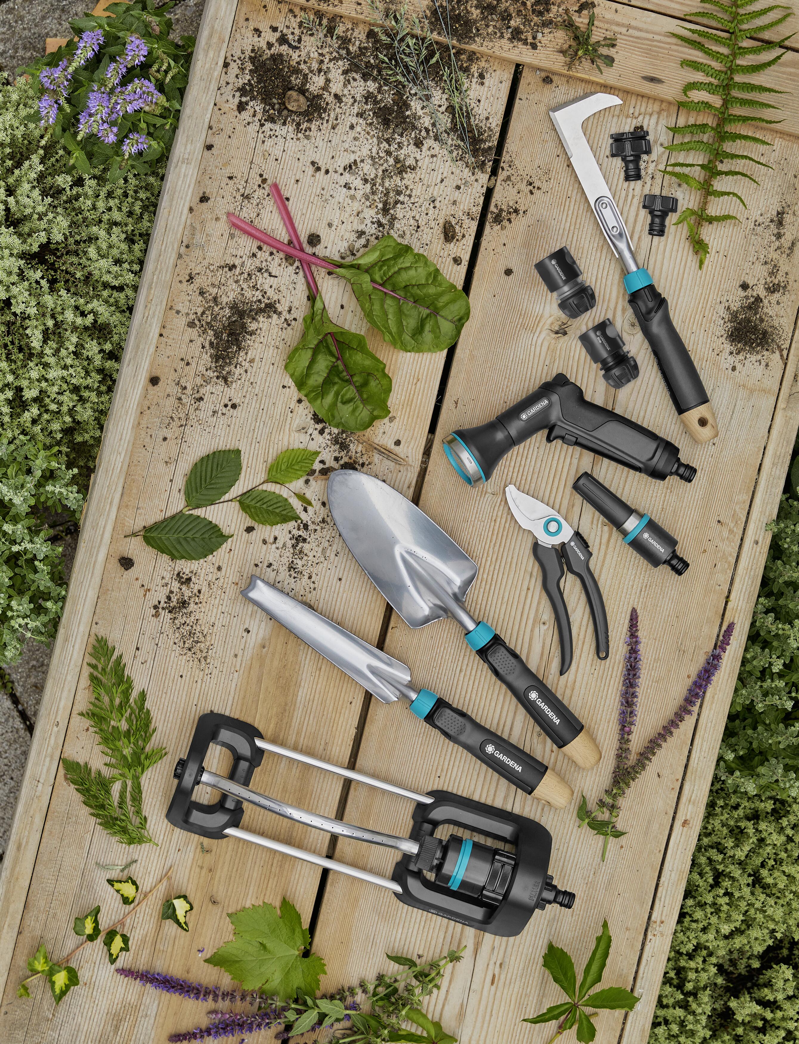 Gardena Ecoline småredskap samlet på bord med planter og gress rundt