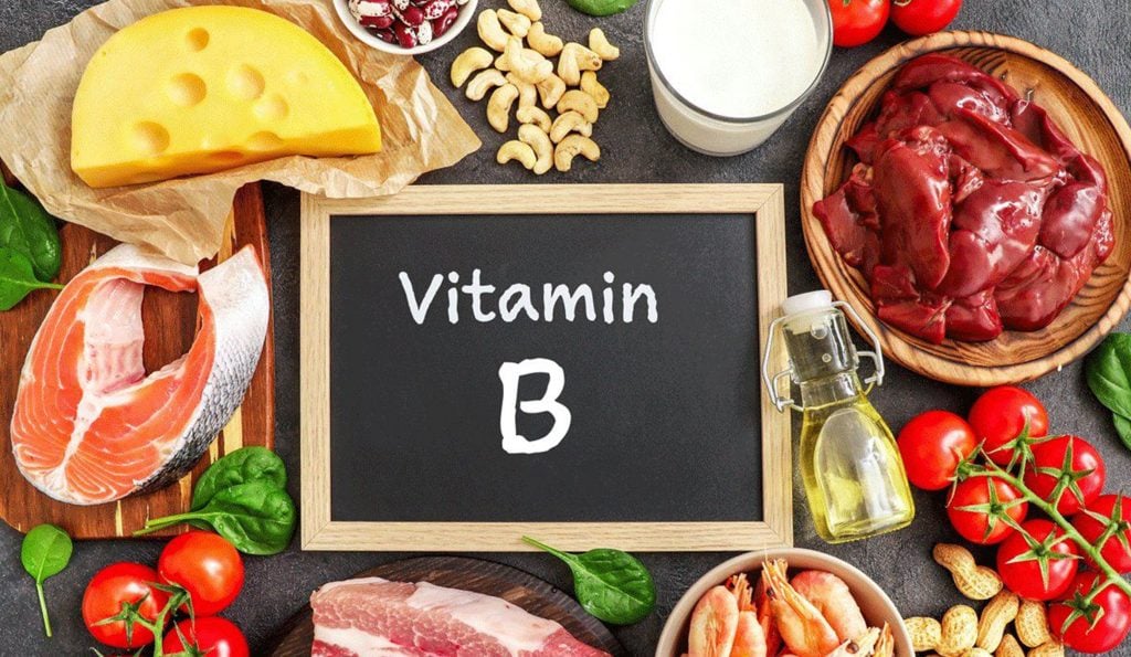 Bilde av en tavle hvor det står vitamin B på et bord med mat. 