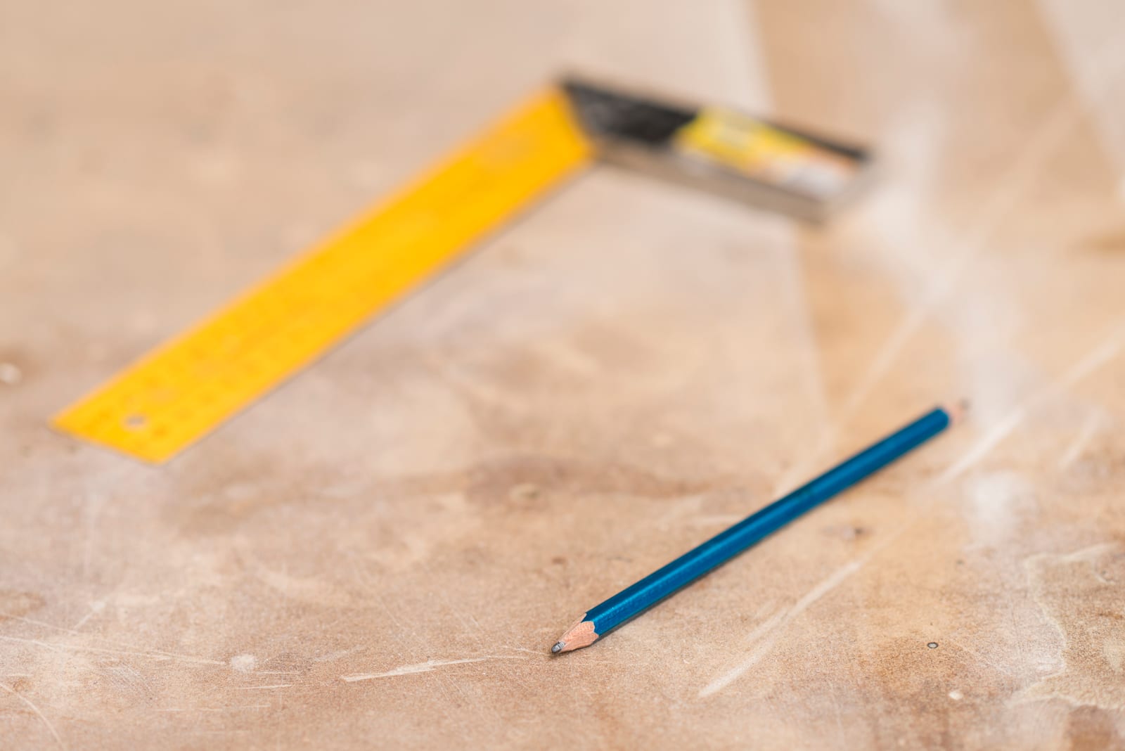 A pencil and a ruler on a wooden surface.