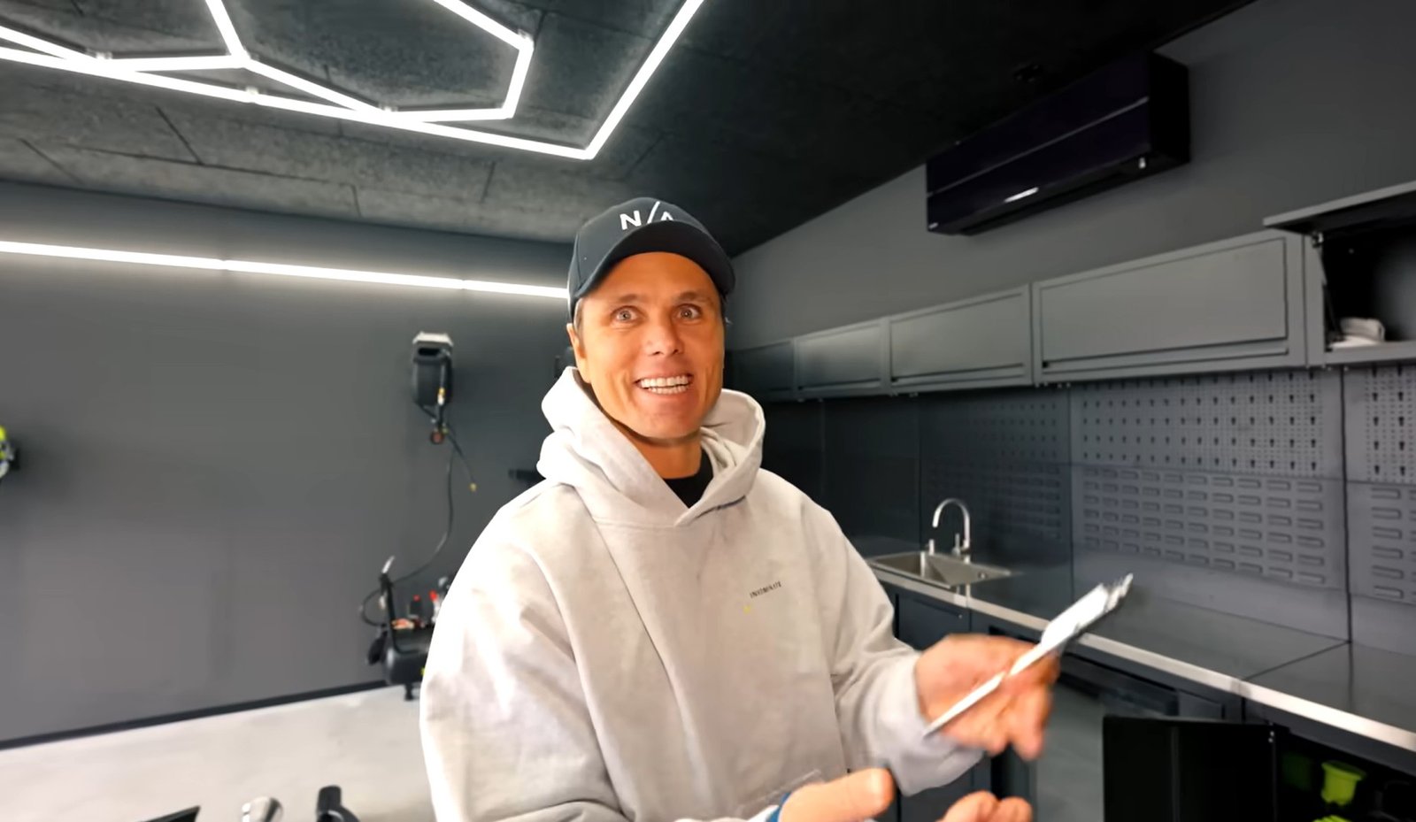 Jon Olsson inne i garaget där HERO syns monterad på väggen.