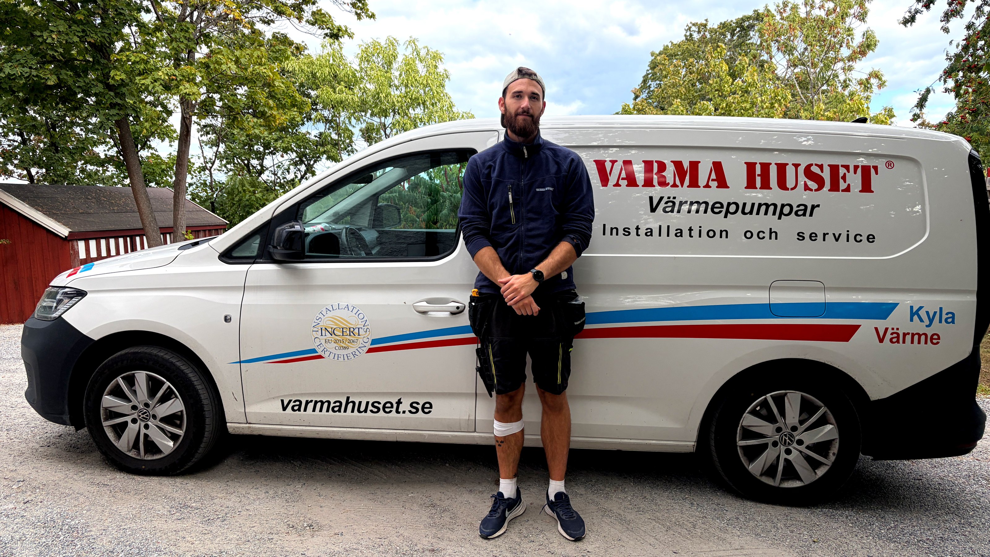Marcus Hellström, värmepumpstekniker, står framför sin företagsbil.
