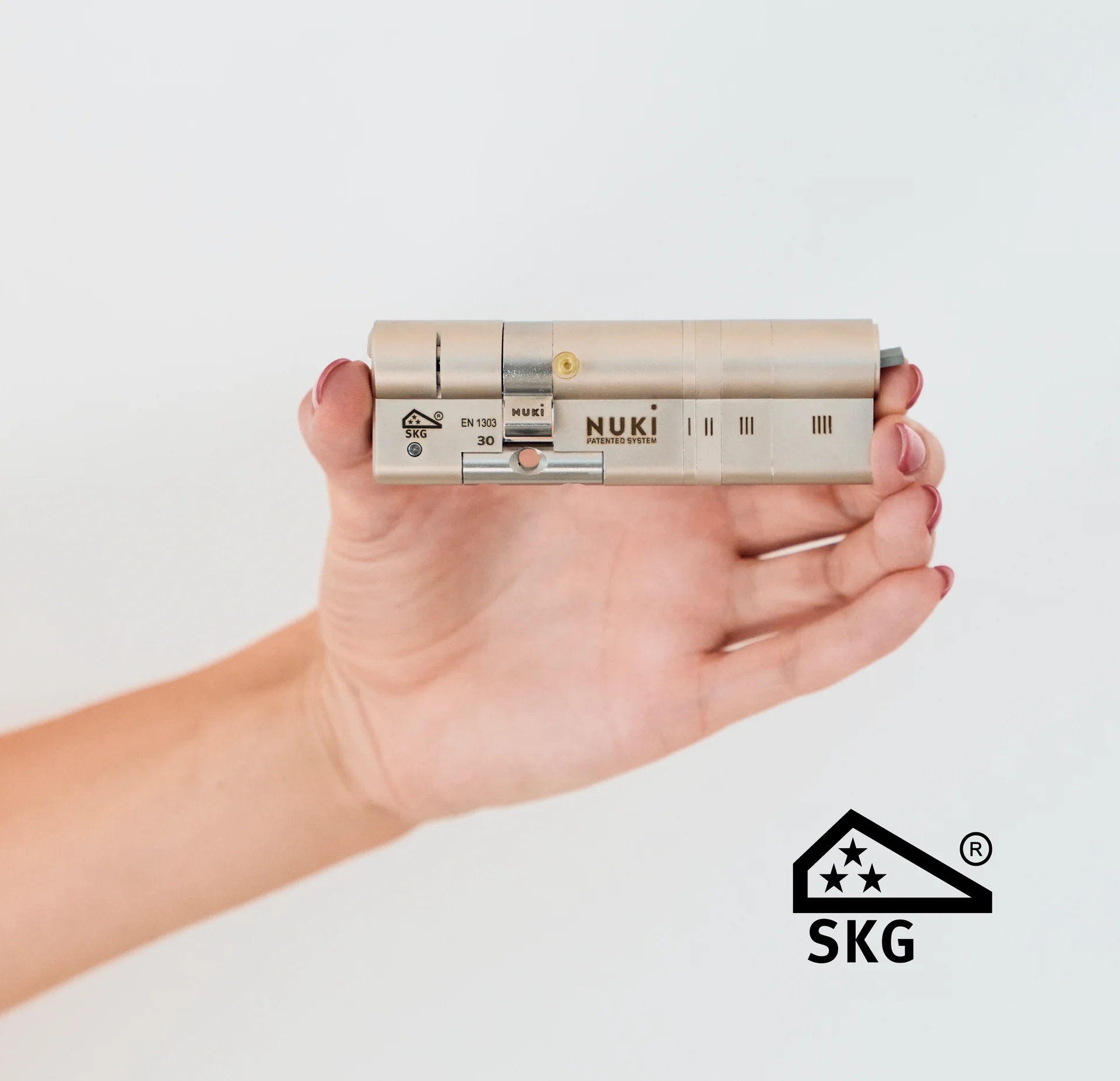 Hand holding a SKG-certified Nuki door cylinder.