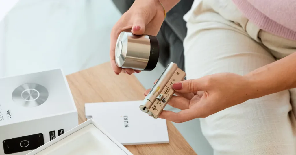 Een vrouw zit en houdt de Smart Lock Ultra en de meegeleverde universele cilinder vast.