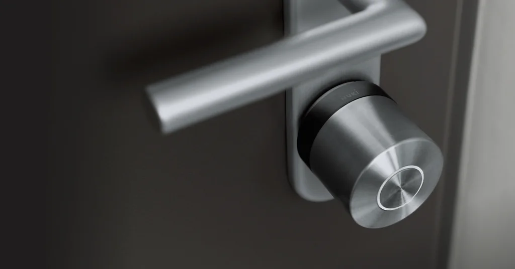 De Smart Lock Ultra met zwarte ring, gemonteerd op een zwarte deur met zilverkleurig beslag.