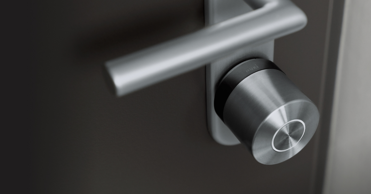 The Smart Lock Ultra with black ring mounted to a black door  with silver hardware.