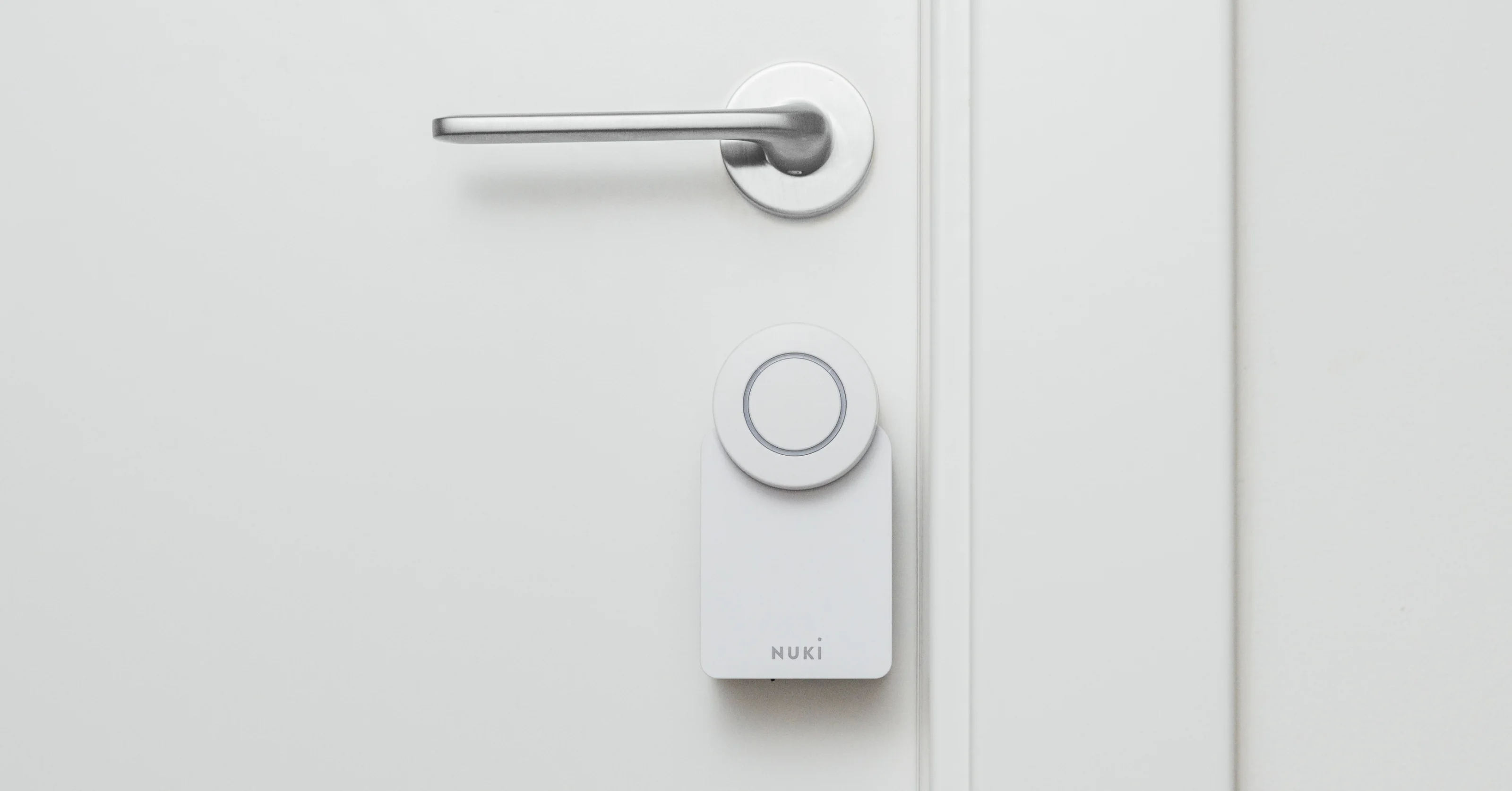 A Smart Lock Go is mounted on a white door with silver hardware. 